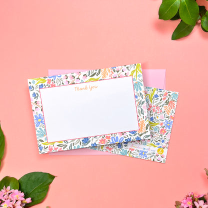 Floral stationery set with a card and envelope on a pink background