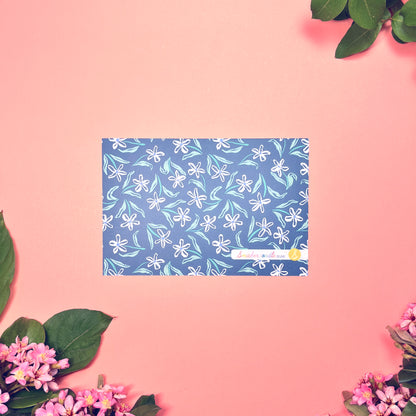 White dainty flower pattern on a blue background with teal and periwinkle accents. Stationery set of 10 with envelopes. Showing back of card by itself.