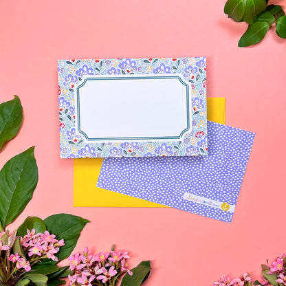 Mahjong inspired flat note set of 10 for greeting cards. Features silver blue paisley pattern with a bamboo hinted frame for a warm handwritten letter. Lilac periwinkle pebble pattern printed on back. Shown on a yellow envelope.