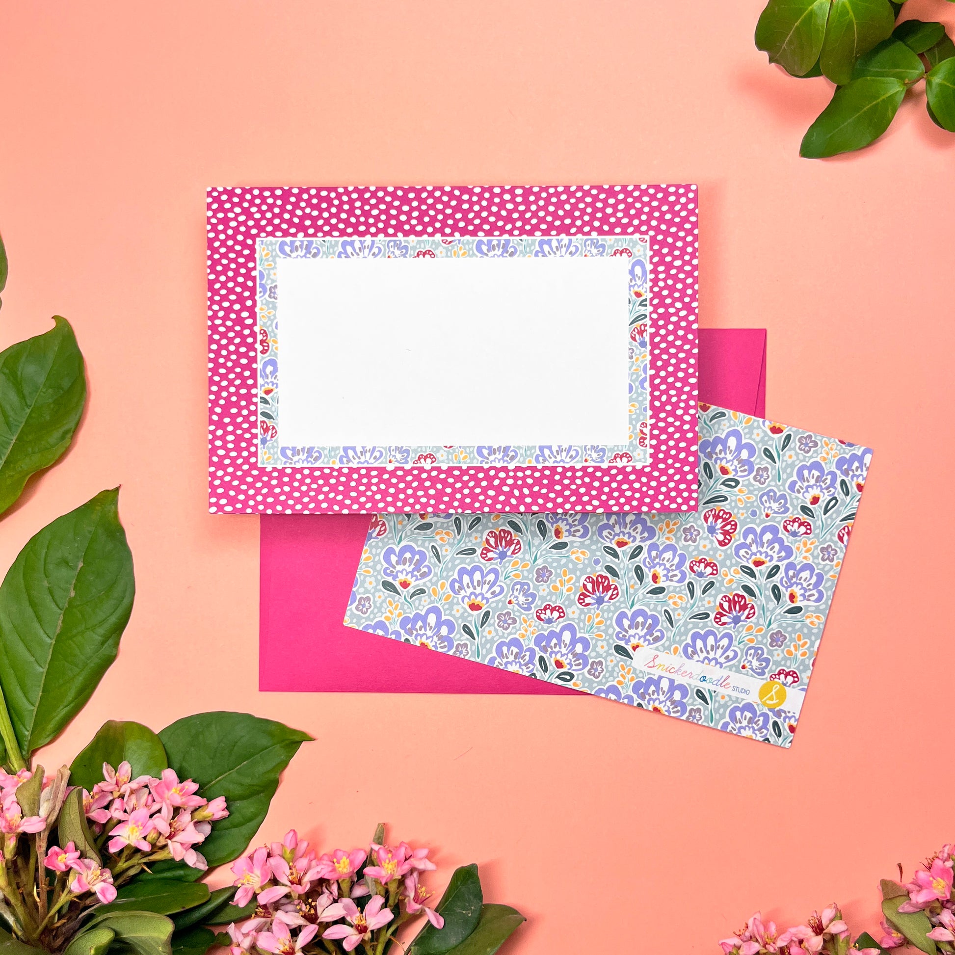 Floral stationery set of 10 with wine-pink polka dot border and silver blue paisley pattern. Shown with a magenta envelope.