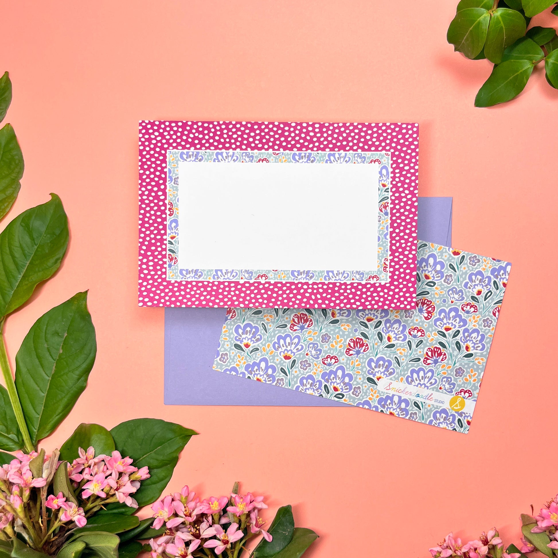 Floral stationery set of 10 with wine-pink polka dot border and silver blue paisley pattern. Shown with a lilac envelope.