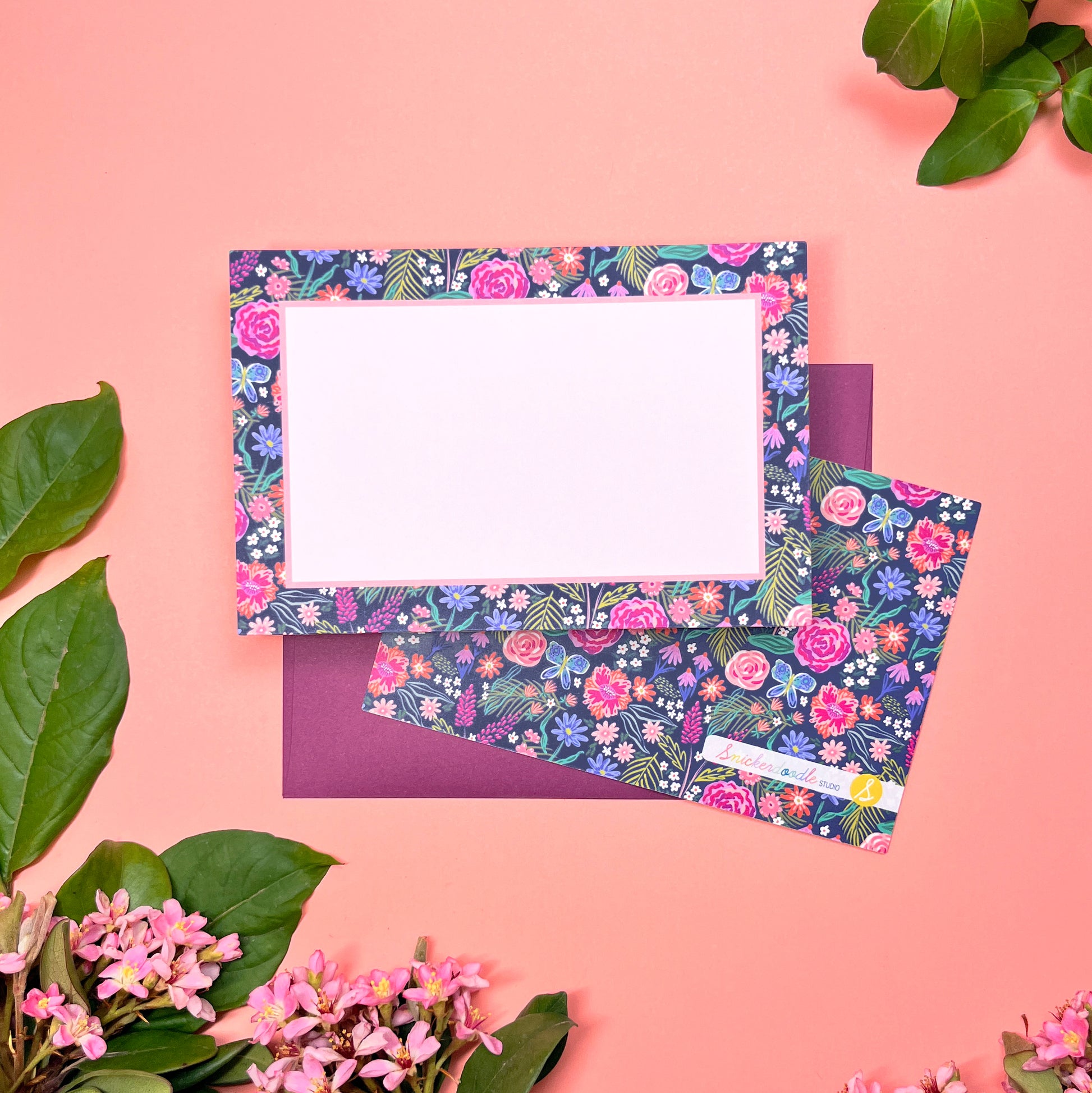 The Summer Night Floral pattern shows beautifully calm, but bright florals on a deep navy background with a bright blue butterfly. This Stationery set of 10  is perfect for a gentle greeting that still expresses the joy of hope. Shown front and back of card on a deep purple envelope.