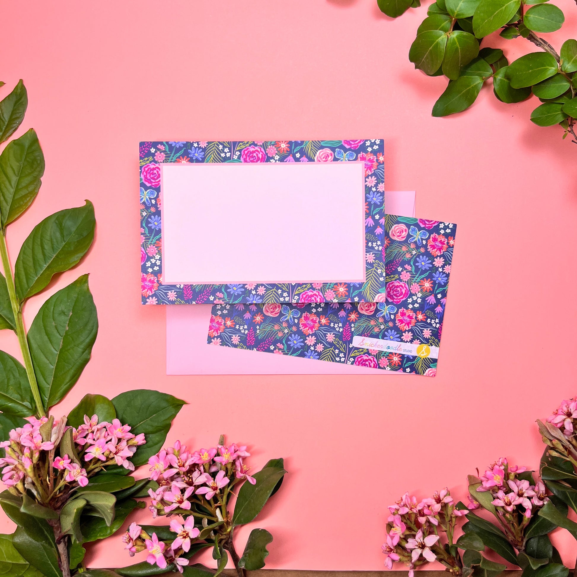 The Summer Night Floral pattern shows beautifully calm, but bright florals on a deep navy background with a bright blue butterfly. This Stationery set of 10  is perfect for a gentle greeting that still expresses the joy of hope. Shown front and back of card on a blush pink/ light pink envelope.