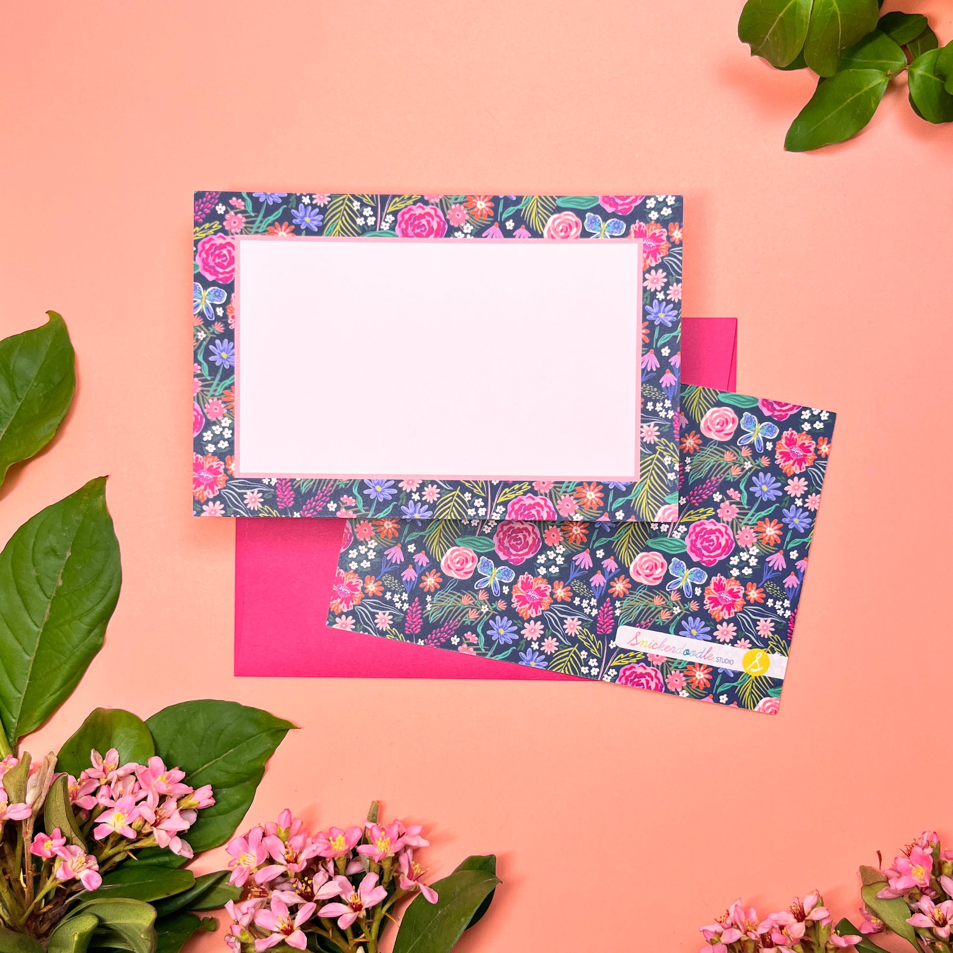 The Summer Night Floral pattern shows beautifully calm, but bright florals on a deep navy background with a bright blue butterfly. This Stationery set of 10  is perfect for a gentle greeting that still expresses the joy of hope. Shown front and back of card on a magenta envelope.